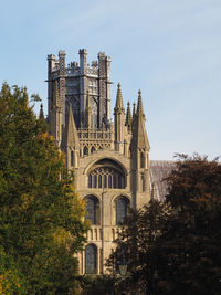 Low angle view of trees and buildings against sky