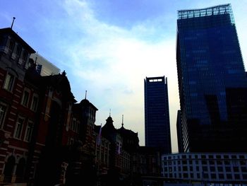 Low angle view of buildings against cloudy sky