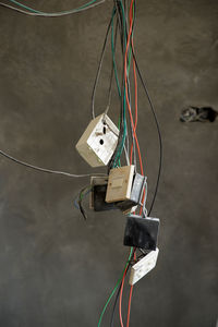 Close-up of sockets with wire tied up on wall