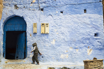 Full length rear view of man against building