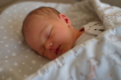 Portrait of cute newborn baby lying on blanket