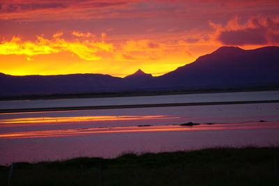 Scenic view of silhouette mountains against romantic sky at sunset