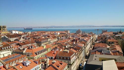 High angle view of townscape by sea against clear sky