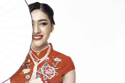 Portrait of smiling young woman against white background