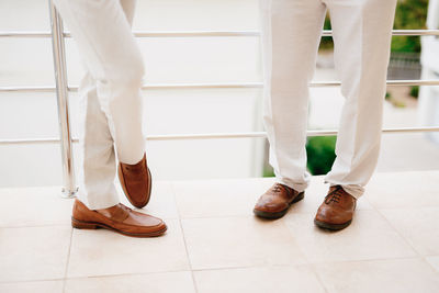 Low section of man standing on tiled floor