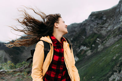 Young happy laughing carefree woman with hair blowing in the wind.