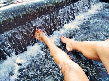 Low section of woman at waterfall