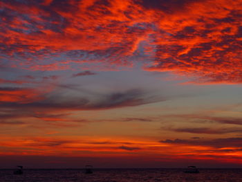 Scenic view of sea against dramatic sky during sunset