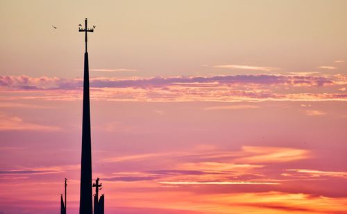 Low angle view of silhouette street light against dramatic sky