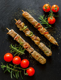 Skewers of mixed meat and grilled vegetables on slate