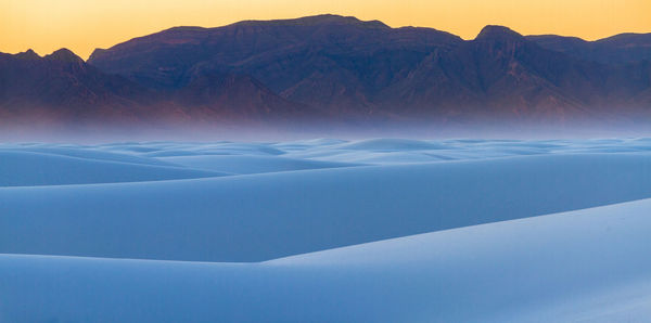 Scenic view of snow covered mountains against sky