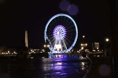 Illuminated ferris wheel at night