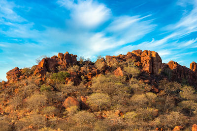 Rock formations on landscape against cloudy sky