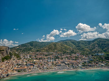 High angle view of townscape by sea against sky