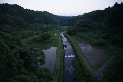 High angle view of road amidst trees against sky