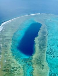 High angle view of sea shore against blue sky