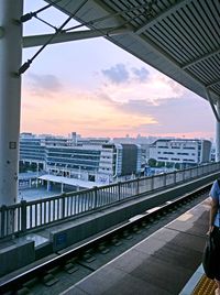 Train at railroad station in city against sky