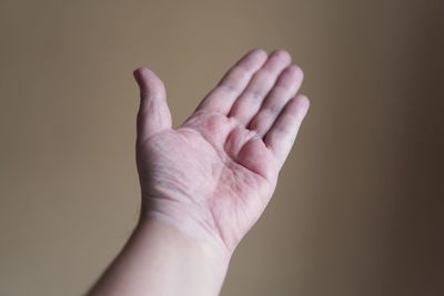 Close-up of person hand against gray background