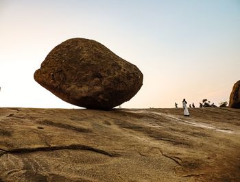 Rock formation on land against clear sky during sunset