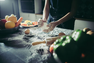 Midsection of preparing food in kitchen at home