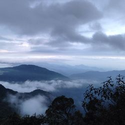 Scenic view of mountains against cloudy sky