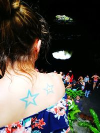 Rear view of people standing at night