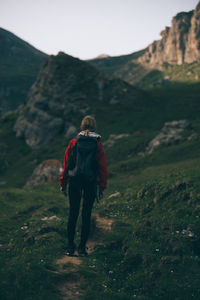 Full length rear view of woman walking on mountain