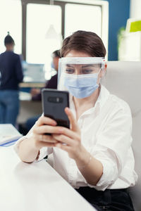 Young woman using mobile phone in laboratory