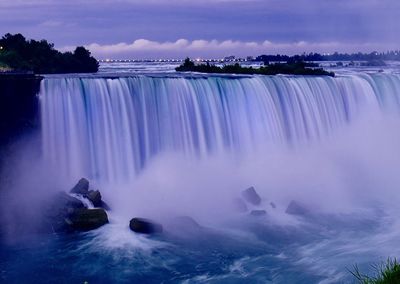 Scenic view of waterfall against sky