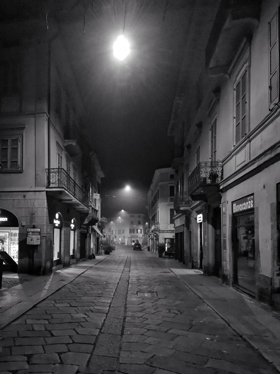 EMPTY ALLEY ALONG BUILDINGS AT NIGHT