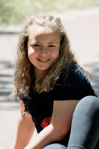 Portrait of a smiling girl sitting outdoors