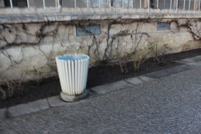 Close-up of ice cream on footpath against wall