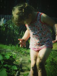 Girl with messy legs standing on land