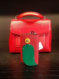 Close-up of red purse on wooden table