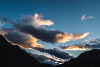 Low angle view of silhouette mountains against dramatic sky
