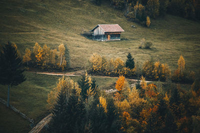 House by lake in forest against sky