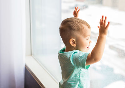 Cute boy looking through window