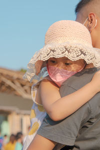 Father holding in arms asian little girl wear facemask during coronavirus and flu outbreak.