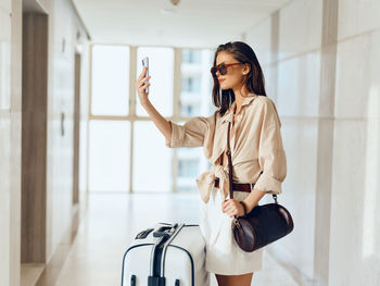 Young woman using mobile phone while standing in gym