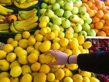 Cropped hand holding lemon at market stall