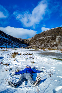 High angle view of boy making snow angel during winter