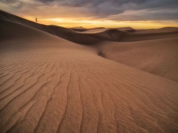 Scenic view of desert against sky during sunset