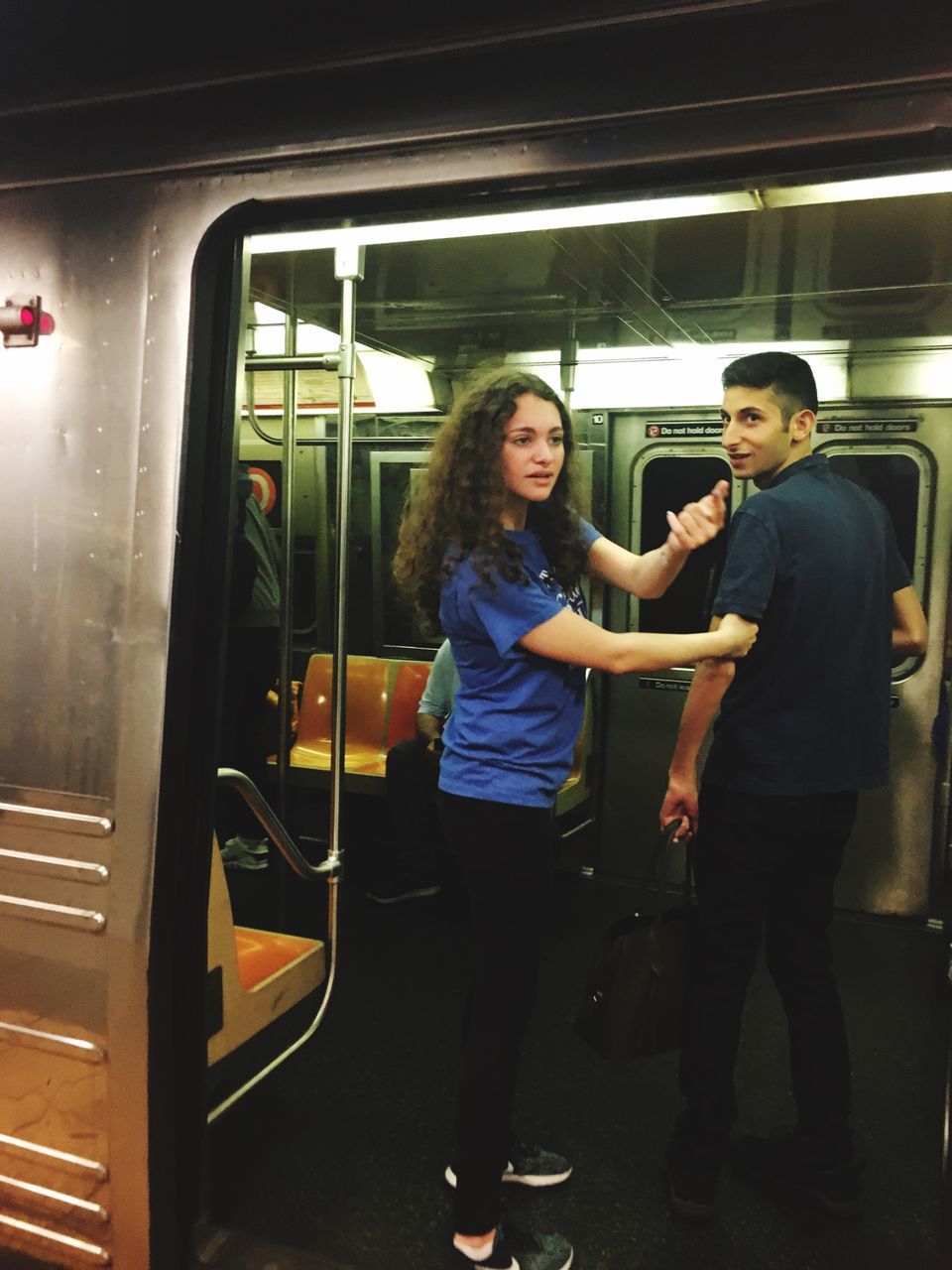 rail transportation, real people, train, public transportation, mode of transportation, two people, casual clothing, transportation, people, full length, standing, indoors, women, adult, travel, young adult, window, train - vehicle, lifestyles, architecture, subway train