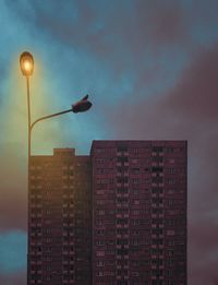 Low angle view of illuminated street light against building