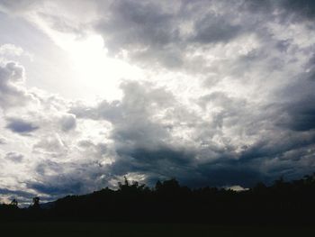 Silhouette trees on field against sky