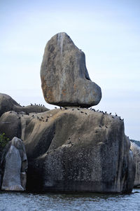 Rock formations in sea against sky