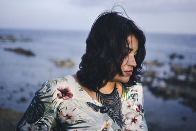 Midsection of woman at beach against sky