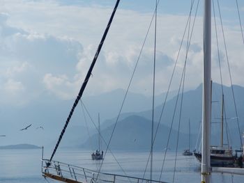 Boats moored in calm sea against sky