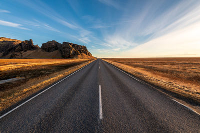 Road passing through landscape against sky