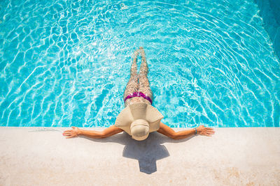 Young blonde woman relaxing in swimming pool at spa resort - relaxing concept
